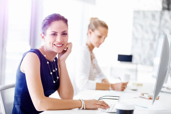 Attractive office worker sitting at desk — Stock Photo, Image