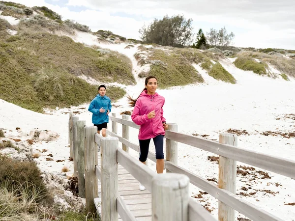 Jeune couple courant le long de la mer — Photo