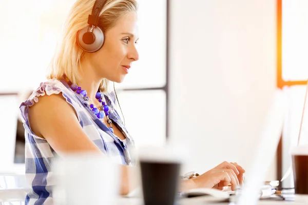 Young woman in the office with headphones — Stock Photo, Image