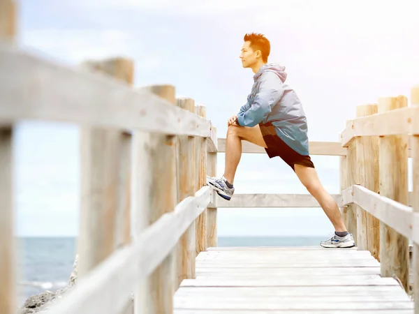Jonge man doen oefening op het strand — Stockfoto