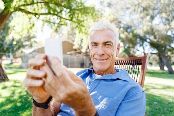 Lomature man buitenshuis gebruik mobiele telefoon — Stockfoto