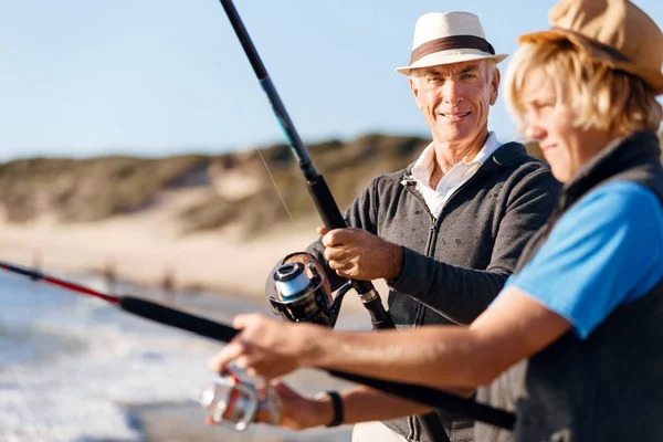 Uomo anziano pesca con suo nipote — Foto Stock