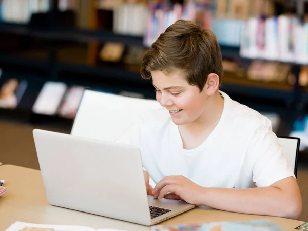 十几岁的男孩在图书馆中的平板电脑 — 图库照片