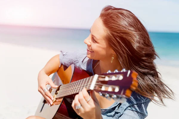 Piękna młoda kobieta gra na gitarze na plaży — Zdjęcie stockowe