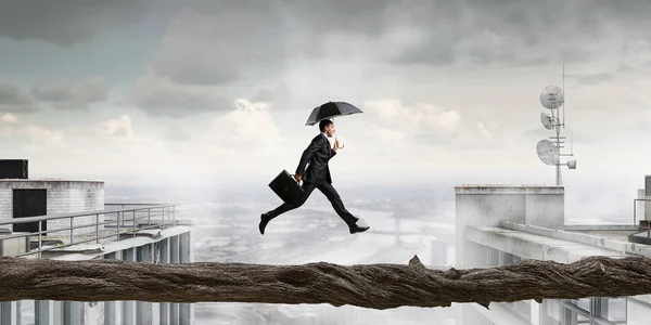Onverschrokken zakenman overwinnen moeilijkheid. Mixed media — Stockfoto