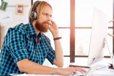 Genç adam ofiste çalışıyor.