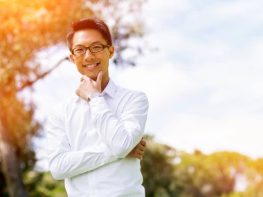 Genç işadamı açık havada otururken dizüstü bilgisayar kullanarak