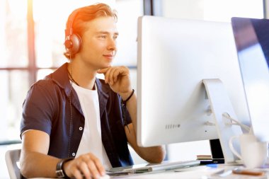 Kulaklıklar ile ofiste genç adam