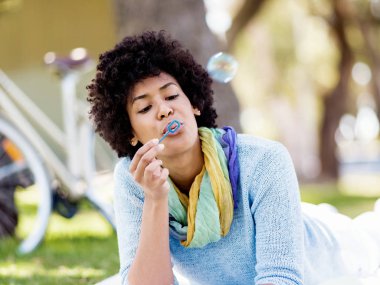 Güzel kadın parkta kabarcıklar üfleme