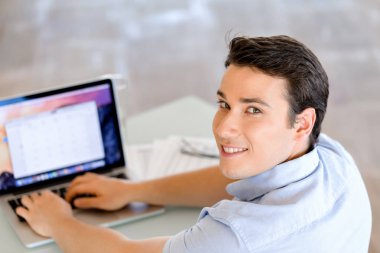 Bilgisayarda çalışan yakışıklı işadamı