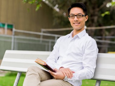 Not Defteri ile bankta oturmuş çekici düşünceli işadamı