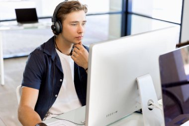 Kulaklıklar ile ofiste genç adam