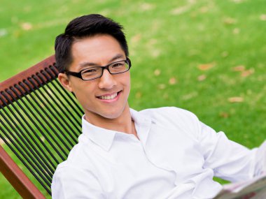 İş adamı parkta bir gazete okuyor