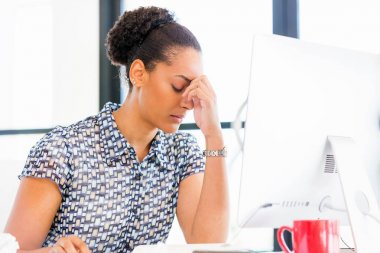 İş içinde oturan yorgun Afro-Amerikan ofis çalışanı portresi