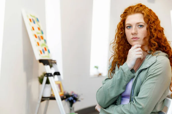 Jovem mulher caucasiana na galeria de arte frente de pinturas — Fotografia de Stock