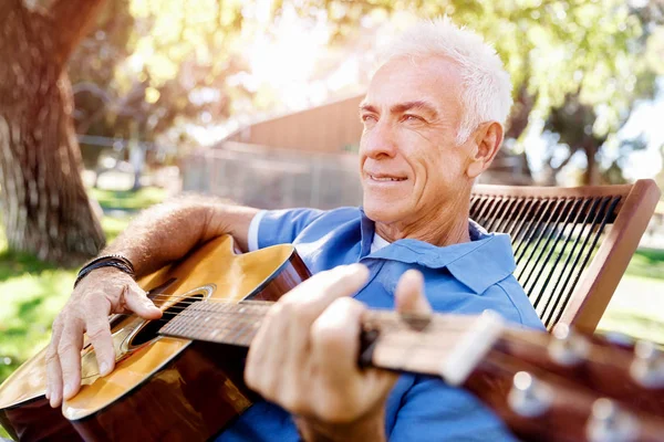 Старший чоловік лежить на гітарі на відкритому повітрі — стокове фото