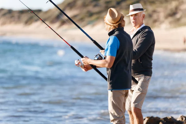 Yaşlı adam torunuyla balık tutuyor.