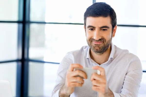 Confident young man in smart casual wear holding phone — Stock Photo, Image