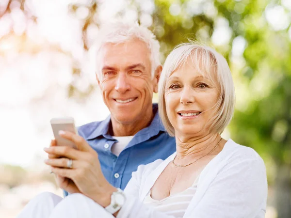 Щаслива старша пара дивиться на смартфон — стокове фото