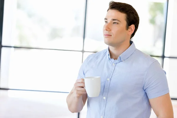 Young businessman in office with a mug — Stock Photo, Image