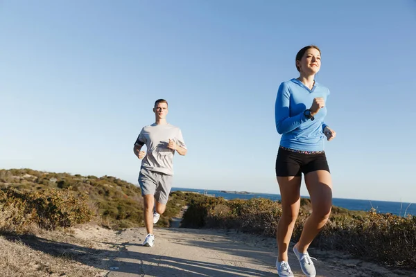 Sportovní běžec zaběhat na pláži cvičit se svým partnerem — Stock fotografie