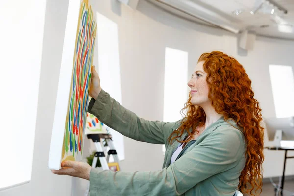 Mujer joven caucásica de pie en la galería de arte frente a las pinturas —  Fotos de Stock