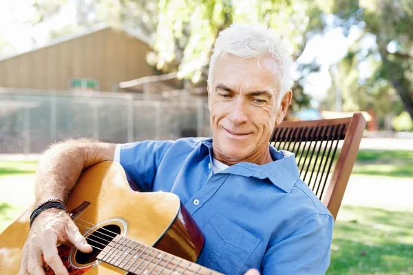 Senior man varen gitaar buitenshuis — Stockfoto