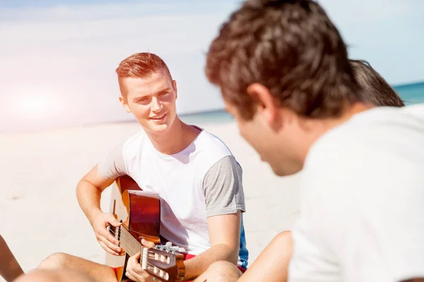 Hermosos jóvenes con guitarra en la playa —  Fotos de Stock