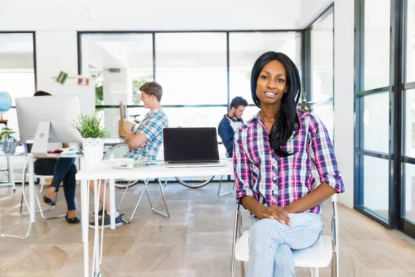 Porträtt av leende afro-american kontorist i offfice med hennes kollegor — Stockfoto