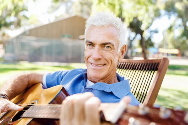 Uomo anziano che suona la chitarra all'aperto — Foto Stock