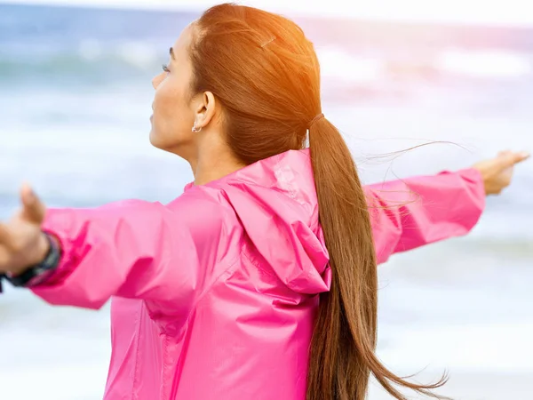 Молодая женщина в спортивной одежде стоит у моря — стоковое фото