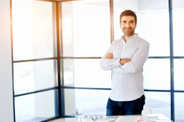 Νεαρός επιχειρηματίας Καυκάσιος στέκεται στο γραφείο — Φωτογραφία Αρχείου