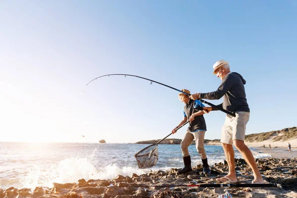 Starší muž rybaří se svým vnukem — Stock fotografie
