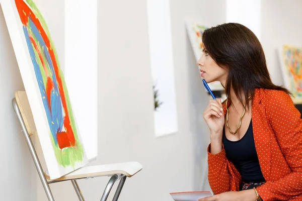 Young caucasian woman standing in art gallery front of  paintings — Stock Photo, Image