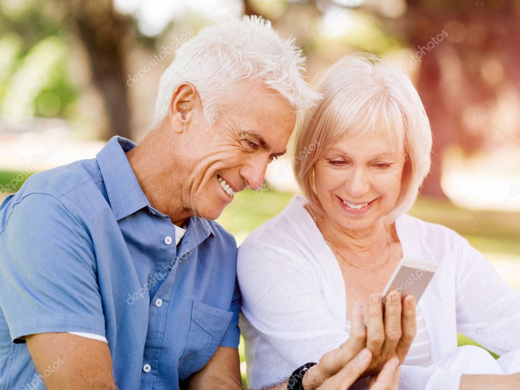 Happy senior couple looking at smartphone