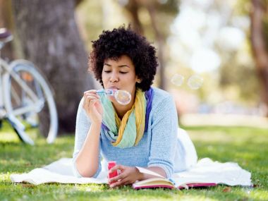 Güzel kadın parkta kabarcıklar üfleme