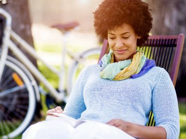 genç kadın parkta bir kitap okuma