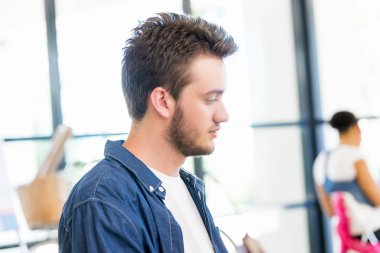 Genç adam ofiste çalışıyor.