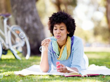 Güzel kadın parkta kabarcıklar üfleme
