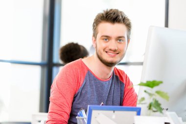 Genç adam ofiste çalışıyor.