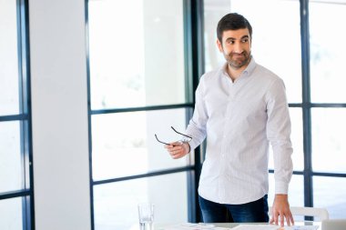 Ofiste duran genç beyaz iş adamı