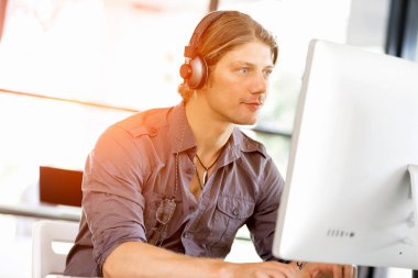 Kulaklıklar ile ofiste genç adam