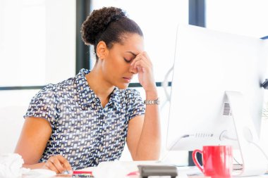 İş içinde oturan yorgun Afro-Amerikan ofis çalışanı portresi