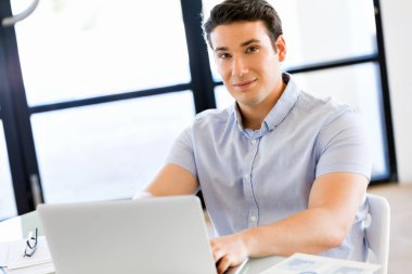 Bilgisayarda çalışan yakışıklı işadamı