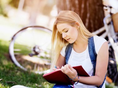 Güzel genç kadın açık havada günlüğüne yazma