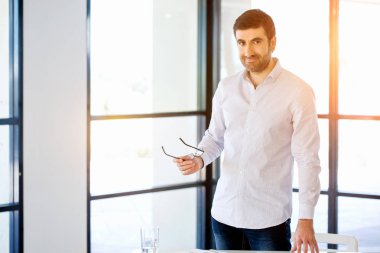 Ofiste duran genç beyaz iş adamı