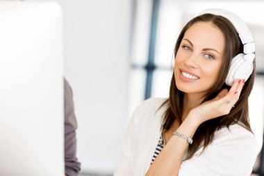 Kulaklıklar ile ofiste genç kadın