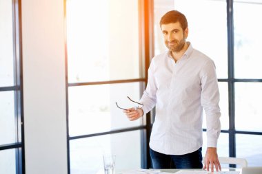 Ofiste duran genç beyaz iş adamı