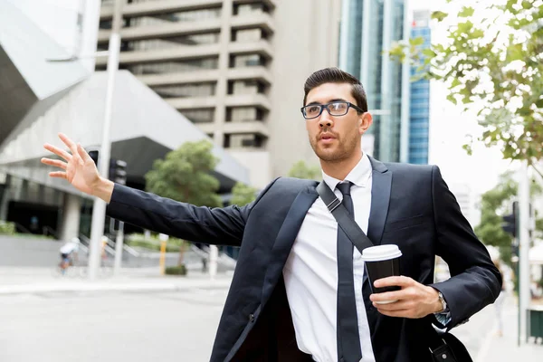 Young businessman hailing for a taxi — Stock Photo, Image