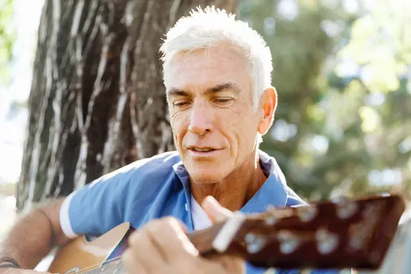 Hombre mayor tocando la guitarra al aire libre — Foto de Stock